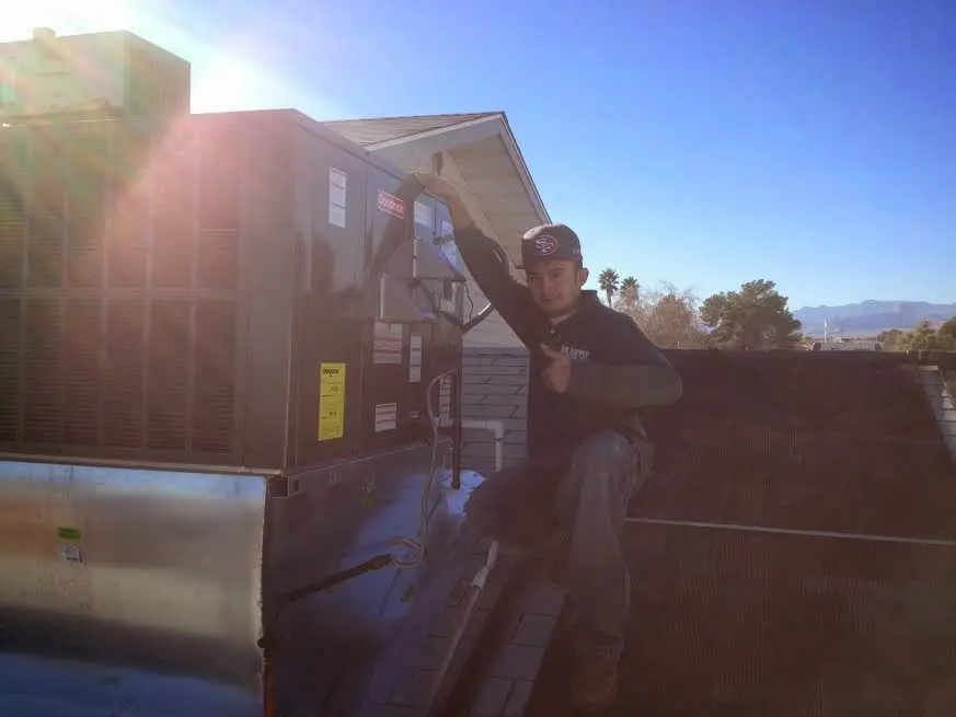 HVAC technician performing AC Tune-Up on a rooftop unit in Hampton